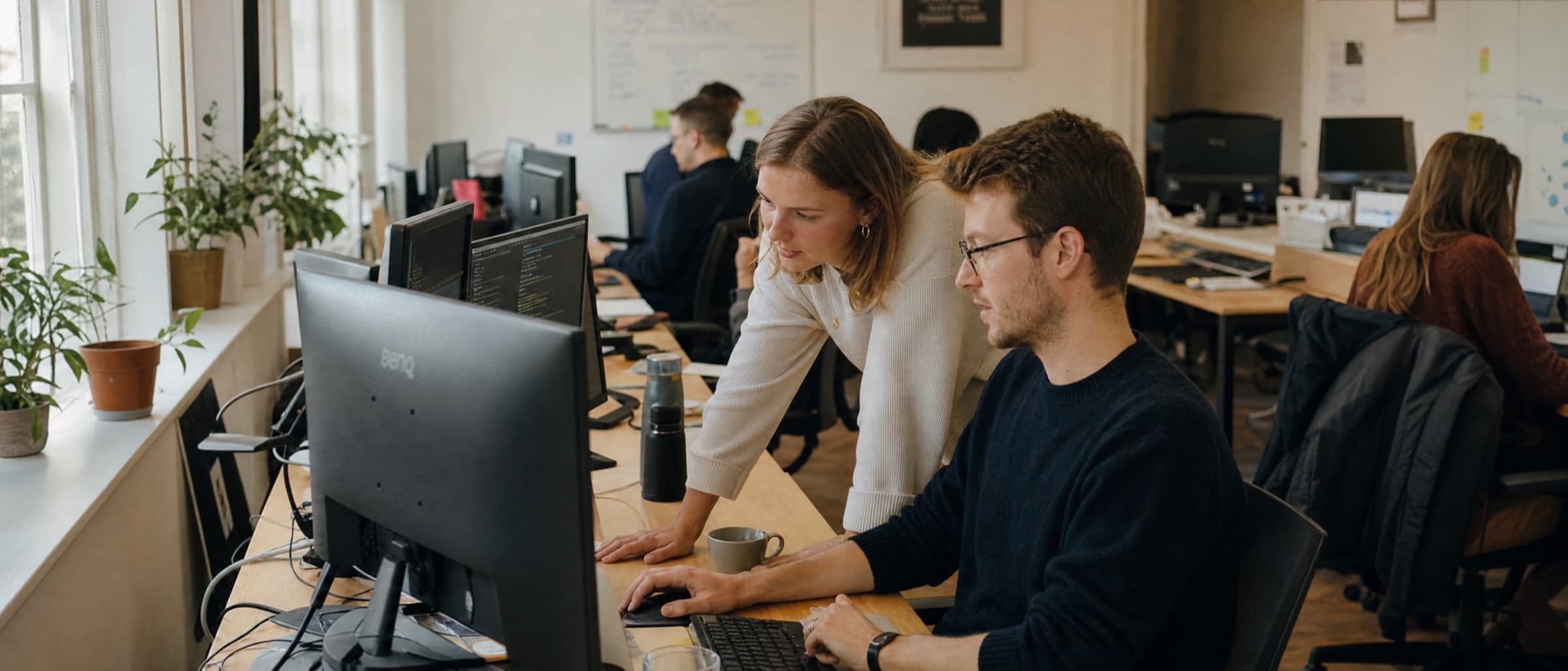 Two colleagues working through a build together at one screen